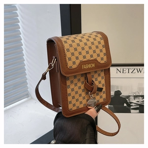 Détail d'un petit sac bandoulière vintage en cuir marron avec lettrage FASHION doré