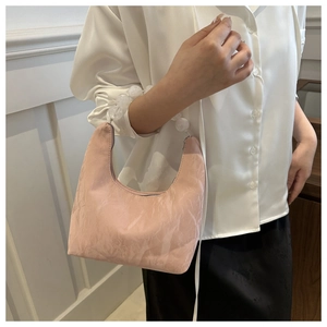 Close-up of light pink shoulder bag featuring large bead chain and wrinkled texture