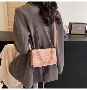 Detailed back view of a pink quilted crossbody bag with wide strap and thick chain
