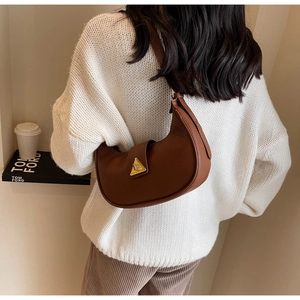 Gros plan du sac sous le bras marron avec une boucle triangulaire en métal doré