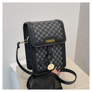Détail du sac bandoulière gris à motif géométrique avec nœud en cuir et pendentif doré