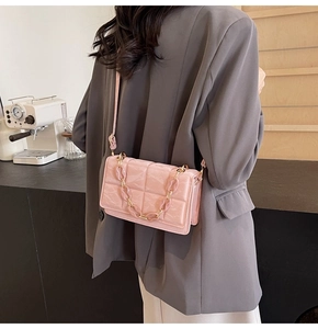 Detailed view of pink quilted crossbody bag with stylish chain strap and glossy finish