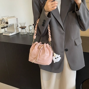 Borsa a secchiello in pelle rosa con manico intrecciato e ciondolo in peluche chic