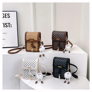 Détail de sacs à bandoulière à carreaux en quatre couleurs avec pendentifs en peluche