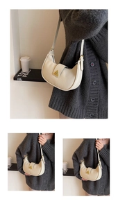 Détail du sac hobo en cuir grainé crème avec boucle triangle dorée et bandoulière