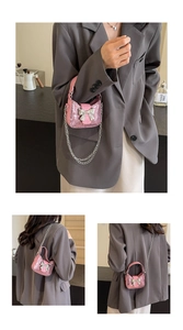 Détail du sac à paillettes roses avec nœud argenté et bandoulière en chaîne métal