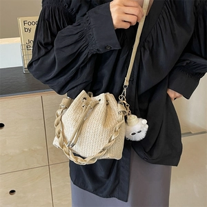 Straw woven bucket bag with drawstring closure and sheep charm for beach vacation