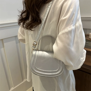 Silver metallic saddle bag with round handle and adjustable strap for women in 2024 fashion