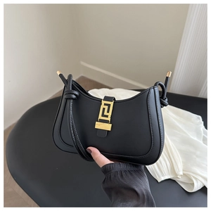 Detail of black underarm bag featuring a vintage gold lock with Greek fret pattern