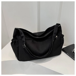 Detail of black canvas tote bag with adjustable side drawstrings and durable handles