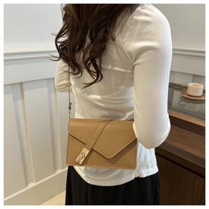 Detail of light brown leather crossbody bag with a vintage gold metal twist lock closure