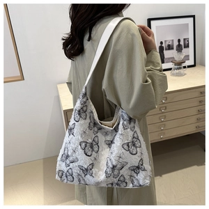 Close-up of canvas shoulder bag showing 3D butterfly lace textures and frayed edge detail