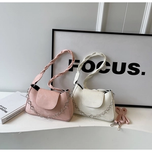 Detail of pink and off-white shoulder bags with woven handles and floral metal chains