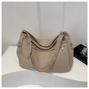 Detail view of khaki canvas tote bag with adjustable strap and drawstring side pocket