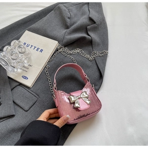 Vue détaillée du mini sac à paillettes roses avec nœud argenté et fine chaîne