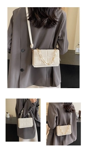 Detail view of cream quilted square crossbody bag with chain and shoulder strap