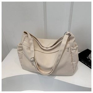 Detail of minimalist canvas tote bag with adjustable strap and side drawstring pocket