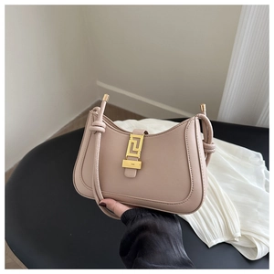 Detail of nude pink leather handbag with gold geometric buckle and knotted strap