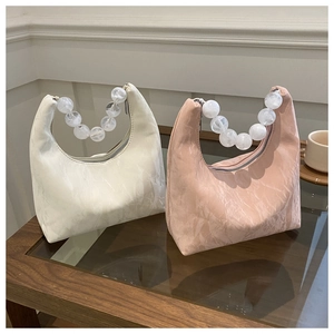 Detail of hobo bags with marble texture and large acrylic beaded chain handles