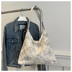 Detailed texture of white lace canvas tote with butterfly print and fringe edges