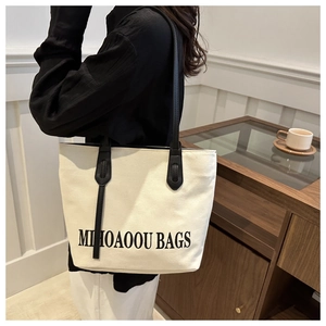 Détail du sac cabas en toile avec lanières en cuir noir et imprimé lettrage MIHOAOOU BAGS