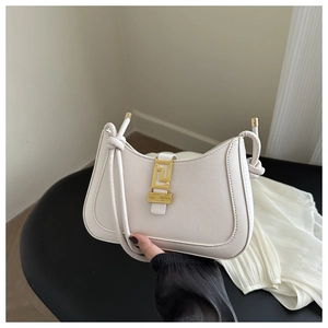 Detail of cream shoulder bag with gold geometric buckle and stylish knot strap design
