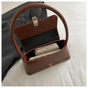 Top view of brown minimalist baguette bag showing internal space for phone and wallet