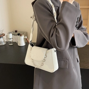 Minimalist white crossbody flap bag with silver clover chain and woven shoulder strap