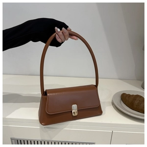 Close-up of caramel retro rectangular underarm bag featuring a gold metal twist lock