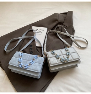 Detailed view of quilted faux suede crossbody bags with acrylic and metal chain handles