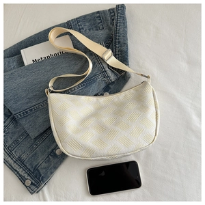 Close-up of woven texture and adjustable nylon strap on this beige crescent tote bag
