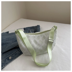 Close-up of a white textured half-moon crossbody bag with adjustable green strap