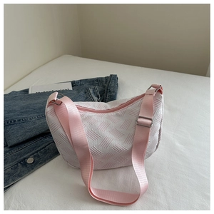 Detail of white and pink woven crescent bag with adjustable nylon shoulder strap