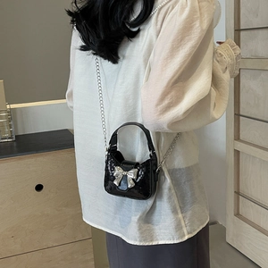Sac bandoulière pailleté noir avec grand nœud en métal argenté et bandoulière