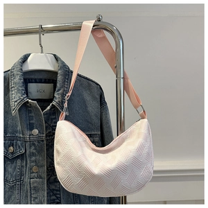 Detail of pink half-moon crossbody bag with geometric weave texture and wide strap