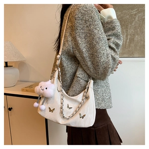 Sac bandoulière blanc à papillons avec chaîne et porte-clé nuage rose porté par mannequin