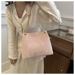 Detail der rosa Tragetasche mit FASHION-Prägung und goldener Ketten-Schultergurt