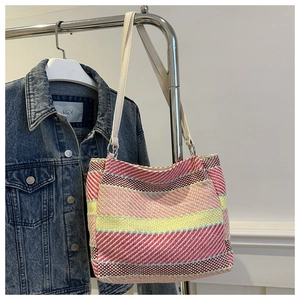 Détail du sac à bandoulière tissé à rayures colorées avec motifs roses jaunes et beige