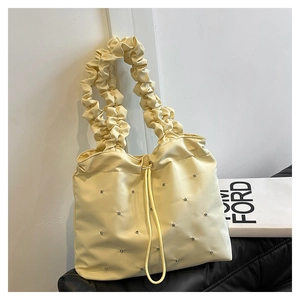 Close-up of cream nylon tote featuring rhinestone accents and elastic ruched handles