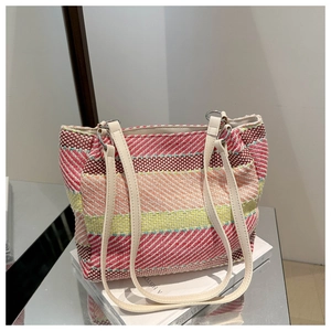 Détail macro d'un sac cabas tissé à rayures colorées avec de fines anses blanches