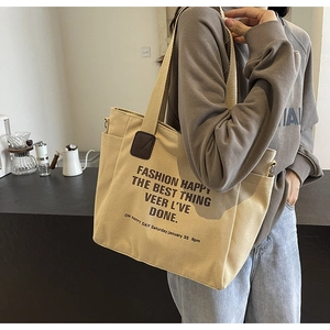 Gros plan d'un sac cabas en toile beige montrant la poche latérale et l'empiècement