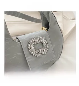 Macro shot of gray marble textured hobo bag with sparkling crystal buckle and gold zipper