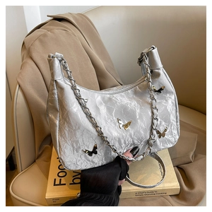 Détails du sac argenté métallisé avec texture plissée et breloques papillon en métal