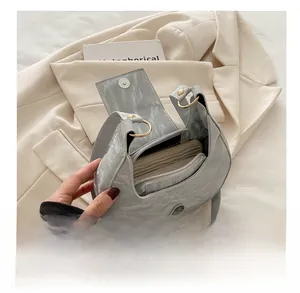Detail of the light grey crescent bag interior showing large capacity and wallet
