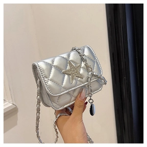 Close-up of silver quilted crossbody bag featuring a diamond-studded star on the flap