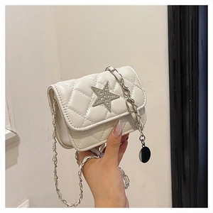 Detail of white quilted crossbody bag featuring a rhinestone star and silver chain
