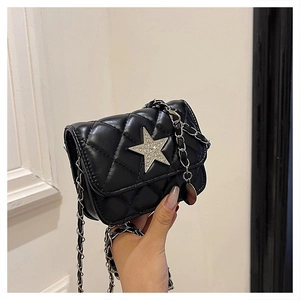 Detail of black quilted mini bag featuring a silver rhinestone star and chain strap