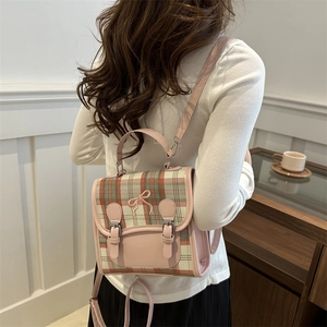 Pink plaid backpack with bow embroidery shown in a cozy lifestyle setting