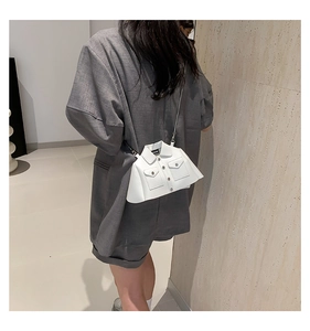 Unique white shirt-shaped mini crossbody bag with silver chain strap shown on a model