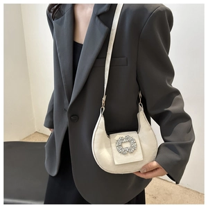 Detail of off-white crescent bag featuring a sparkling rhinestone buckle and PU leather